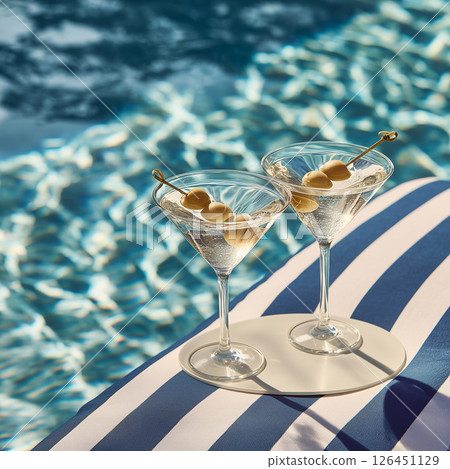 Martini Glasses with Olives on Pool Float in Turquoise Water Under Afternoon Sun Martini Glasses with Olives on Pool Float in Turquoise Water Under Afternoon Sun 126451129