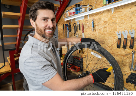 Mechanic in black gloves adjusting wheel Mechanic in black gloves adjusting wheel 126451180