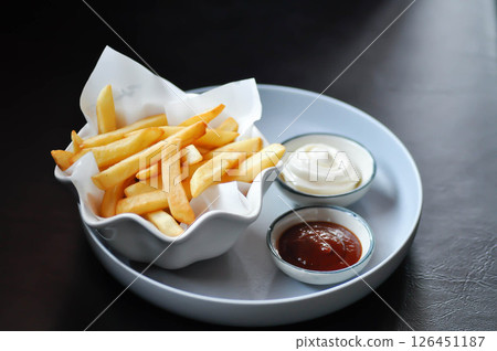 French fries or fried potato , fries with keychup and cheese dip 126451187