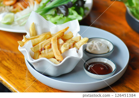 French fries or fried potato , fries with keychup and cheese dip 126451384
