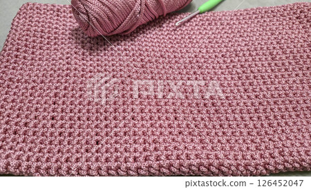 Knitting elements of a pink women's bag, hand knitting with a long handle. Knitting elements of a pink women's bag, hand knitting with a long handle. 126452047