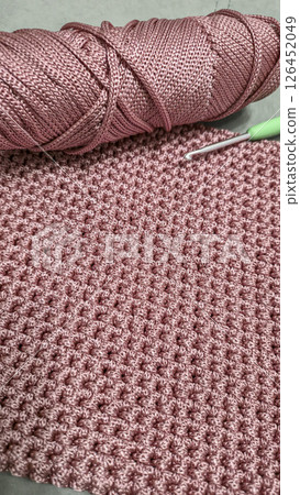 Knitting elements of a pink women's bag, hand knitting with a long handle. Knitting elements of a pink women's bag, hand knitting with a long handle. 126452049