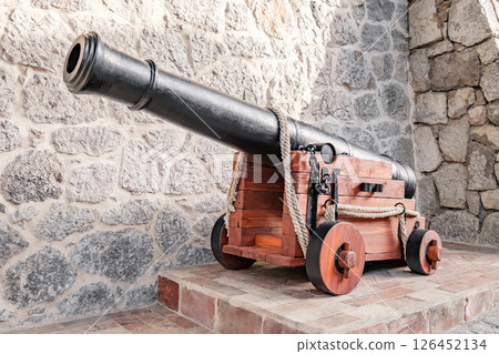 old cannon against background of stone wall of fortress old cannon against background of stone wall of fortress 126452134