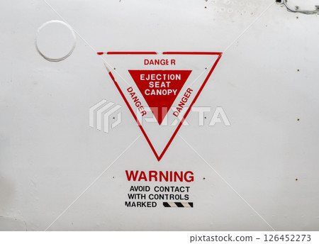 Ejection seat warning sign on the fuselage of an old aircraft Ejection seat warning sign on the fuselage of an old aircraft 126452273