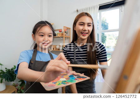 Family time creating art together: Mother and daughter enjoying painting 126452772