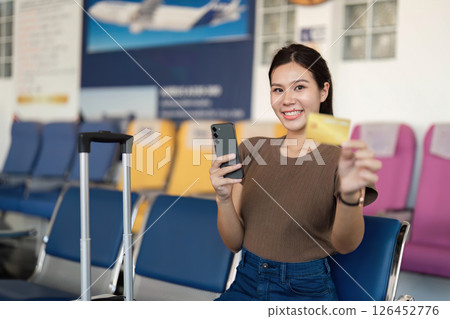 Travel happiness with a young woman holding phone and yellow card Travel happiness with a young woman holding phone and yellow card 126452776