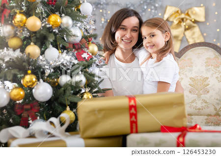 Mom and daughter hugging in Christmas interior Mom and daughter hugging in Christmas interior 126453230