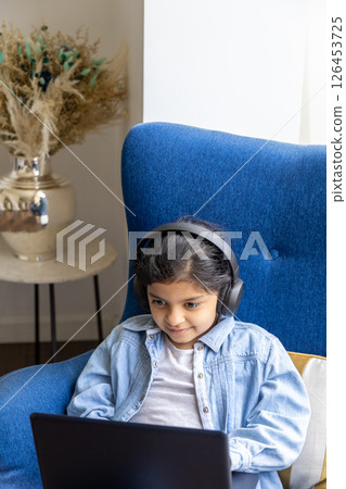 Young girl is using her laptop on the living room Young girl is using her laptop on the living room 126453725