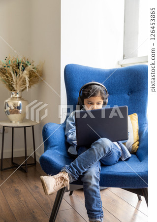 Young girl is using her laptop on the living room 126453865