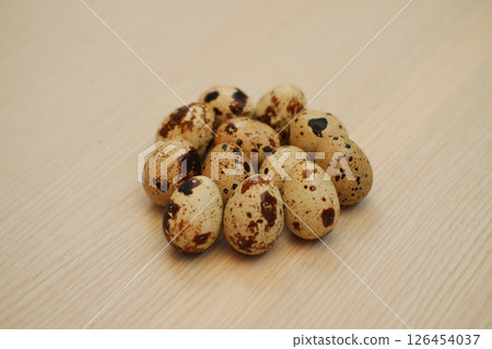 Pile of speckled quail eggs on a wooden surface Pile of speckled quail eggs on a wooden surface 126454037