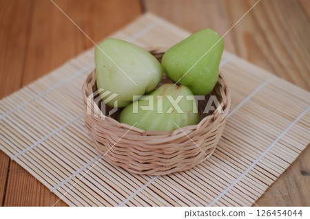 Rose Apple in a Woven Basket on a Wooden Mat Rose Apple in a Woven Basket on a Wooden Mat 126454044