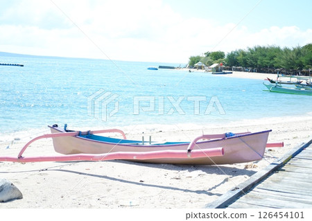 A blue fishing boat floating on the ocean under a bright sunny day 126454101