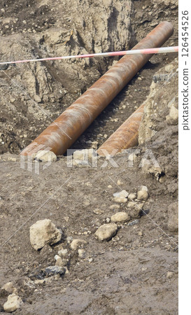 Work on laying utility lines. A large trench and two massive metal pipelines. Work on laying utility lines. A large trench and two massive metal pipelines. 126454526