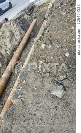 Work on laying utility lines. A large trench and two massive metal pipelines. Work on laying utility lines. A large trench and two massive metal pipelines. 126454528