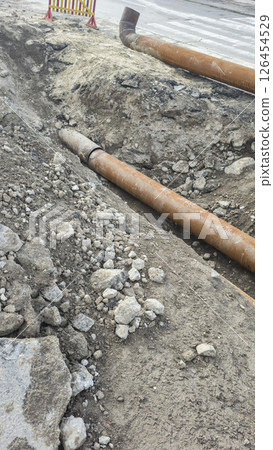Work on laying utility lines. A large trench and two massive metal pipelines. Work on laying utility lines. A large trench and two massive metal pipelines. 126454529