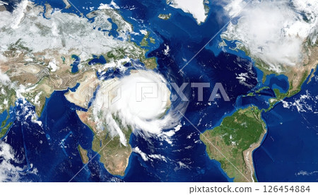 Satellite image of a powerful hurricane forming over the Atlantic Ocean with swirling clouds and intense weather patterns impacting nearby landmasses 126454884