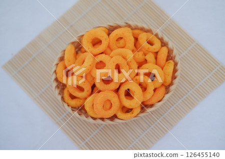 A basket of delicious orange cheese puffs, a popular snack. A basket of delicious orange cheese puffs, a popular snack. 126455140
