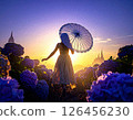 A beautiful woman walking through a flower field with an umbrella 126456230