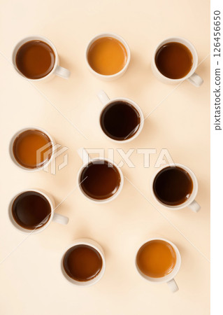 many mugs with different coffee on a pastel table top 126456650