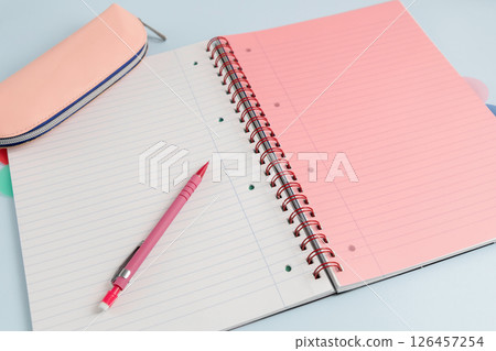 Open blank spiral bound lined notebook with a pencil and a pencil case Open blank spiral bound lined notebook with a pencil and a pencil case 126457254