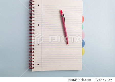 Open blank spiral bound lined notebook and pen Open blank spiral bound lined notebook and pen 126457256