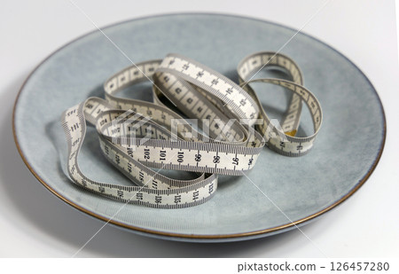 Plate with a measuring tape. Concept of diet and weight loss 126457280
