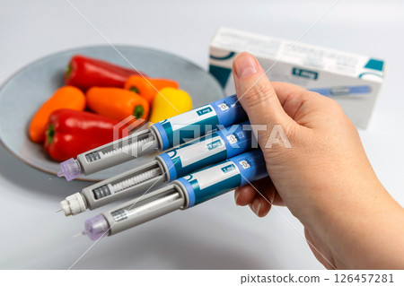 Hands holding Ozempic Insulin injection pen for diabetics and weight loss 126457281