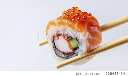 Sushi roll with crab meat and salmon roe held by chopsticks on white background Sushi roll with crab meat and salmon roe held by chopsticks on white background 126457424