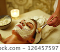 Relaxing facial treatment with soothing mask applied in a calm spa setting during evening hours 126457597