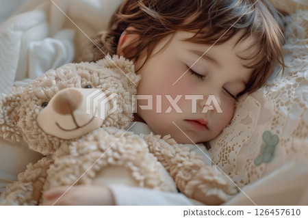 A peaceful toddler sleeping soundly with a stuffed bear in a cozy, softly lit bedroom setting during a serene morning 126457610