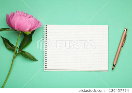 Beautiful pink peony flowers with empty notebook on mint background, copy space for your text or design 126457754