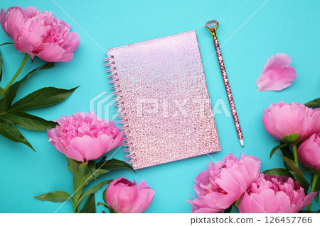 Beautiful pink peony flowers with empty notebook on blue background, copy space for your text or design Beautiful pink peony flowers with empty notebook on blue background, copy space for your text or design 126457766