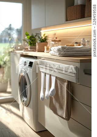 Modern and organized laundry room with hanging garments and folded towels 126459588