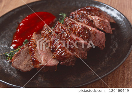 roast duck breast, sliced on a plate, with red sauce, homemade, no people, 126460449