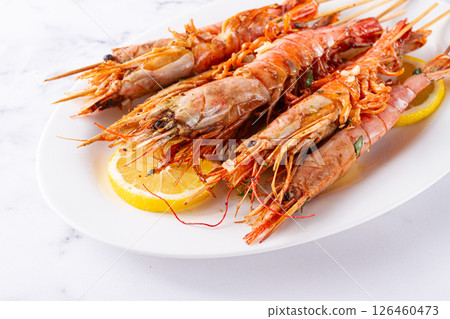 Freshly grilled prawns served, on a white platter ,with lemon slices for a delicious seafood experience 126460473