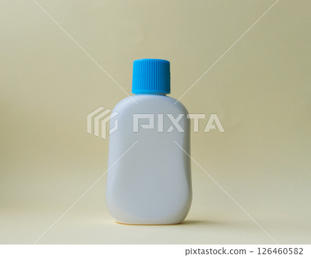 White plastic bottle for cream or oil on the yellow background.  126460582
