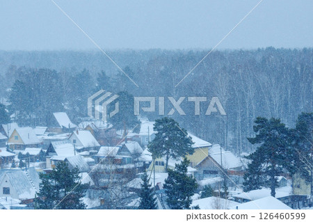 Snowfall blankets a quiet village in the winter season, creating a serene atmosphere and enchanting landscape Snowfall blankets a quiet village in the winter season, creating a serene atmosphere and enchanting landscape 126460599