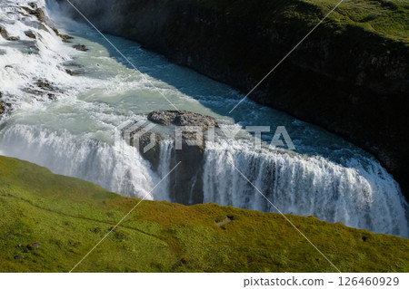 A stream of river is flowing over a rocky shore A stream of river is flowing over a rocky shore 126460929