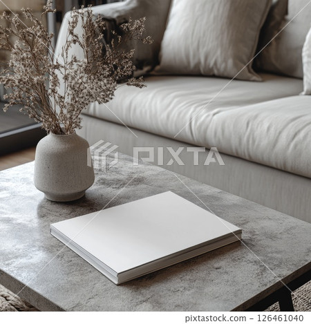 A magazine mockup featuring blank white sheets displayed on a minimalist coffee table. The high detail and muted tones create a casual and stylish vibe, perfect for modern design presentations. 126461040