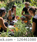 People working together to create a butterfly-friendly garden, with colorful flowers attracting butterflies, soft reflections and shadows, in a sunny, eco-friendly setting 126461080