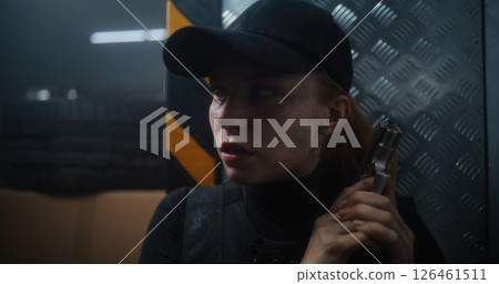 Close Up of Female Secret Agent Hiding Behind Cover in Dark Office Building, Holding a Pistol Close Up of Female Secret Agent Hiding Behind Cover in Dark Office Building, Holding a Pistol 126461511