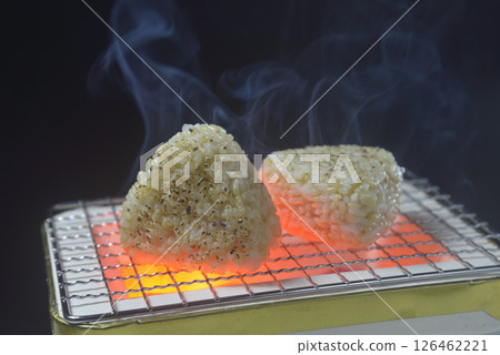 Brown rice balls grilled on a charcoal grill with rising smoke Brown rice balls grilled on a charcoal grill with rising smoke 126462221