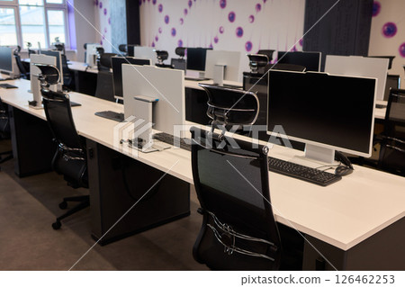 A contemporary office workspace designed with modern computers and elegant desks for professionals 126462253