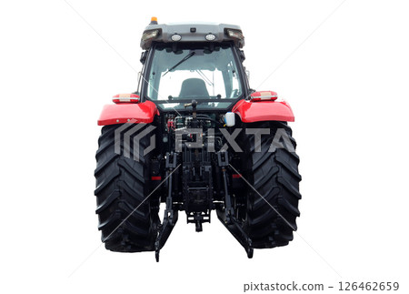 The red farm tractor stands prominently, viewed from the back, highlighting its large tires and agricultural machinery. It is parked in an open field, reflecting a typical day on the farm. 126462659