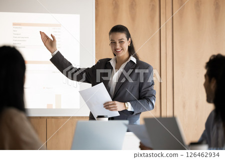 Young female trainer presenting visual data to diverse seminar participants 126462934