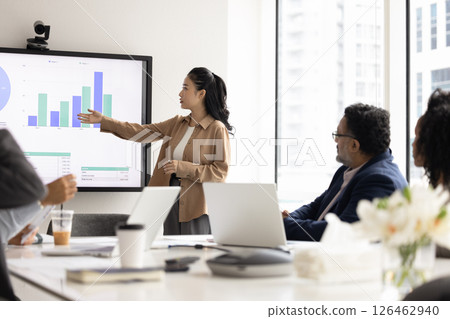 Diverse team members listen young Asian woman professional gives presentation 126462940
