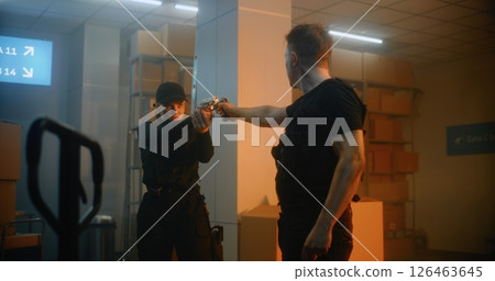 Armed Confrontation: Man and Woman Aiming Guns at Each Other and Talking 126463645