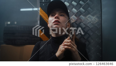 Female Police Officer Hiding Behind the Wall in Dark Office Building, Holding a Gun 126463646