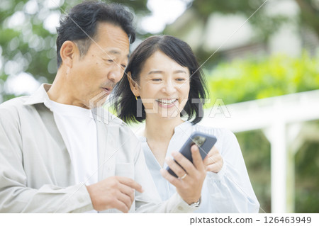 Senior couple looking at a smartphone outdoors 126463949