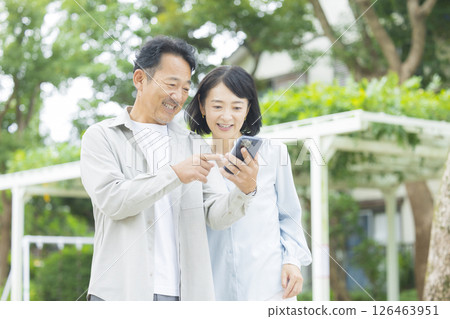Senior couple looking at a smartphone outdoors Senior couple looking at a smartphone outdoors 126463951